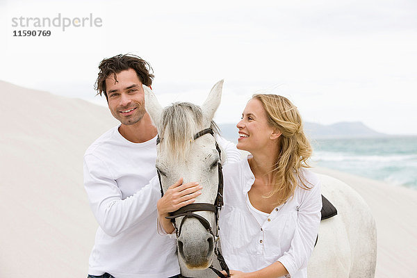 Paar mit Pferd am Strand