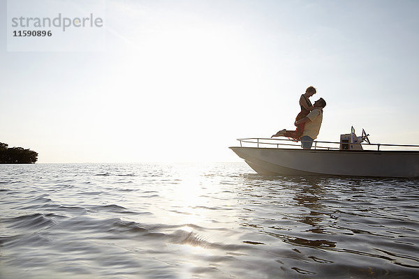 Älteres Ehepaar umarmt sich auf einem Motorboot