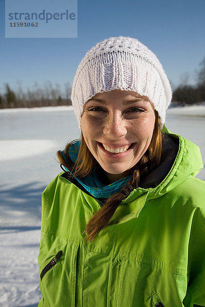 Frau lächelt am zugefrorenen See