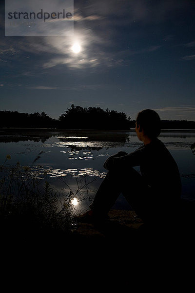 Frau beobachtet Mond über See