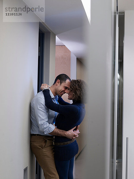 Küssende Paare in einem Bürokorridor