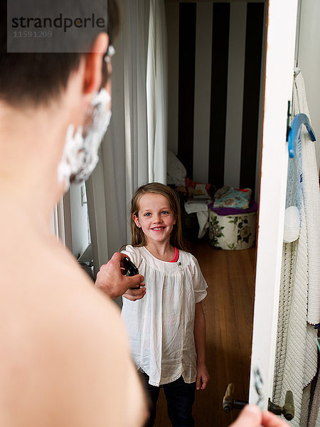 Tochter gibt Handy an Vater im Badezimmer ab