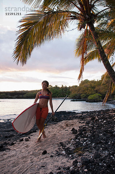 Surfer mit Surfbrett am Strand