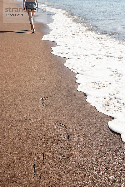 Fußabdrücke von Frauen am Strand