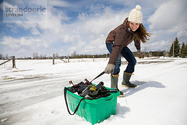 Frau schleppt Recycling im Schnee