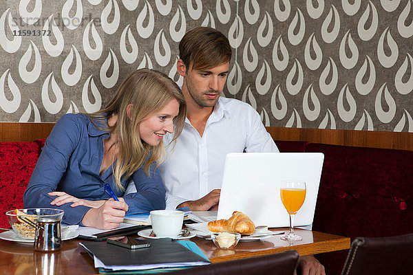 Ehepaar beim Lernen mit Laptop im Cafe