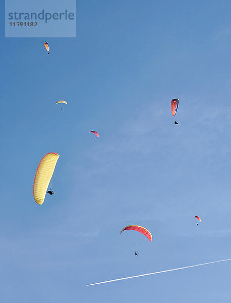 Gleitschirmfliegen bei blauem Himmel