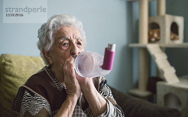 Seniorin mit Inhalator zu Hause