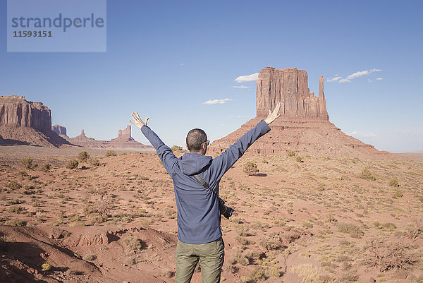 USA  Utah  Rückansicht eines Mannes mit erhobenen Armen mit Blick auf Monument Valley