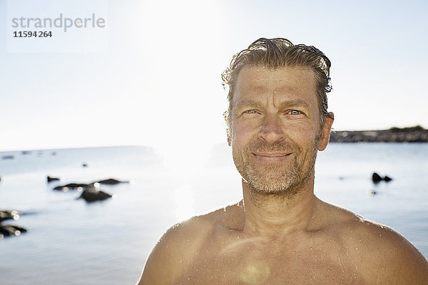 Porträt eines lächelnden Mannes vor dem Meer