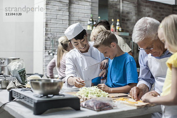 Köchin beim Kochen mit Kindern im Kochkurs