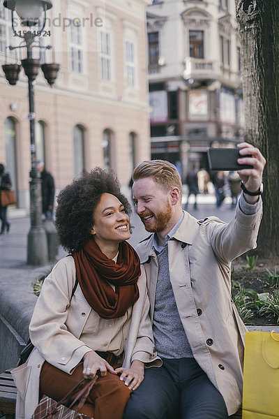 Ein glückliches Paar  das einen Selfie in der Stadt nimmt.
