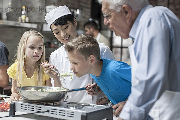 Köchin lässt Kind von der Bratpfanne riechen