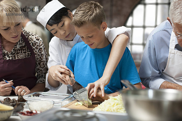 Köchin unterrichtet den Jungen im Kochkurs