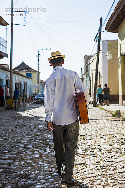 Kuba  Trinidad  Rückansicht eines Mannes mit Gitarre auf der Straße
