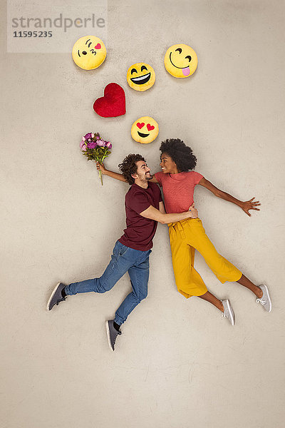 Ein glückliches Paar  das sich über den Kopf in Emojies verliebt.