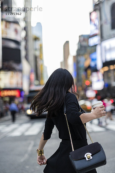 USA  New York City  Manhattan  Rückansicht der Frau mit Kaffee auf der Straße