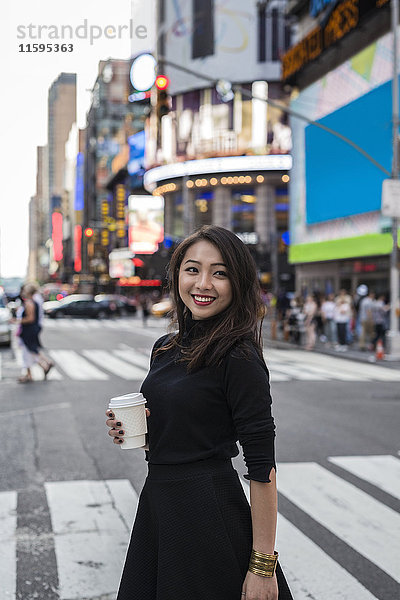 USA  New York City  Manhattan  fröhliche junge Frau mit Kaffee auf die Straße gehen