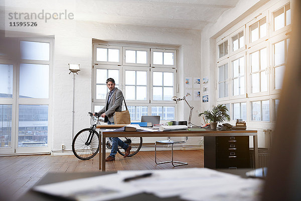 Mann mit Fahrrad in einem modernen informellen Büro