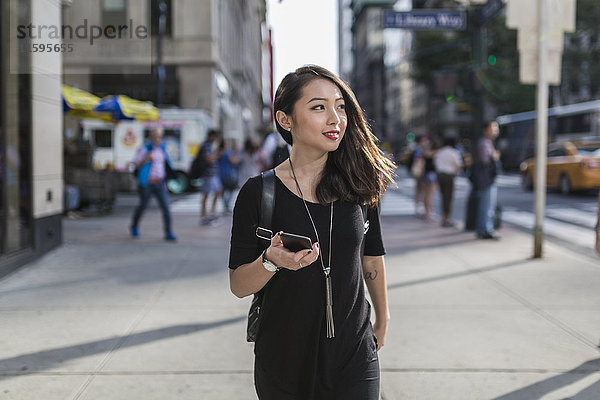 USA  New York City  Manhattan  Portrait einer jungen Frau mit schwarzem Handy
