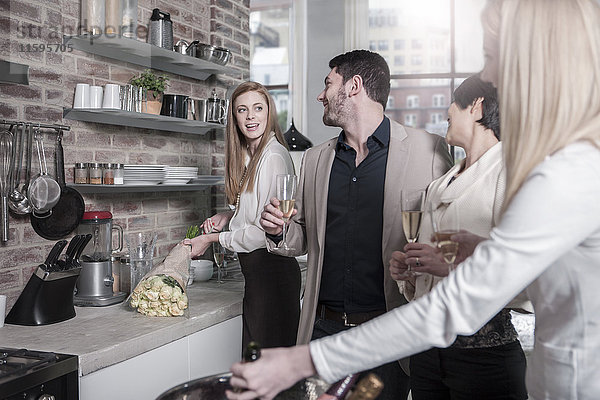 Freunde mit Champagnergläsern in der Küche