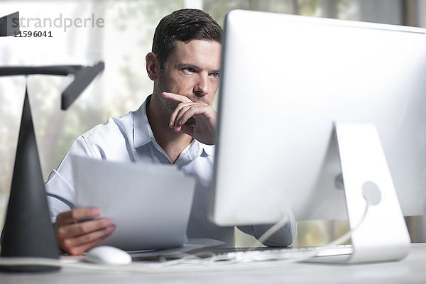 Mittlerer Erwachsener Geschäftsmann  der im Büro arbeitet