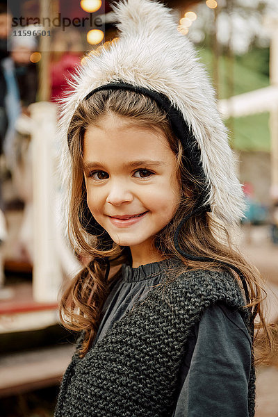 Porträt eines lächelnden kleinen Mädchens mit Fellmütze