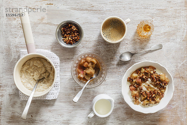 Frühstück mit Schüssel Brei mit Rhabarberkompott  Honig und Nüssen und Tasse Kaffee