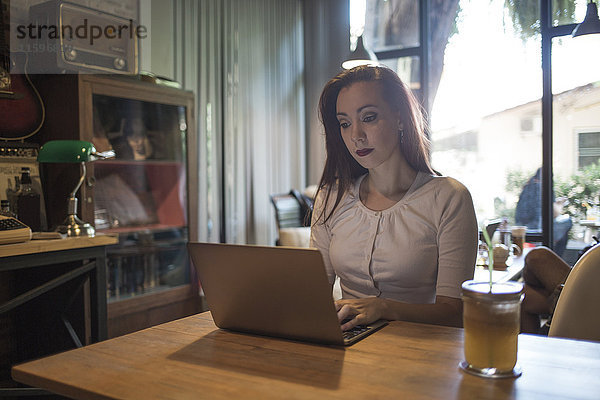 Frau mit einem Laptop in einem Café