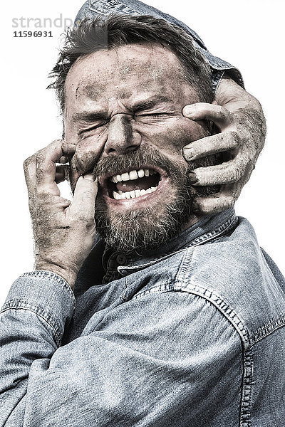 Porträt eines schreienden Mannes mit schmutzigem Gesicht