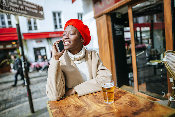Junge Frau in Paris  die im Café sitzt und telefoniert