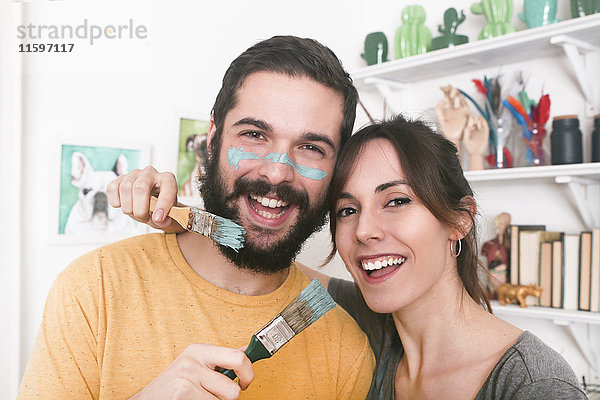 Porträt eines glücklichen jungen Paares mit Pinseln