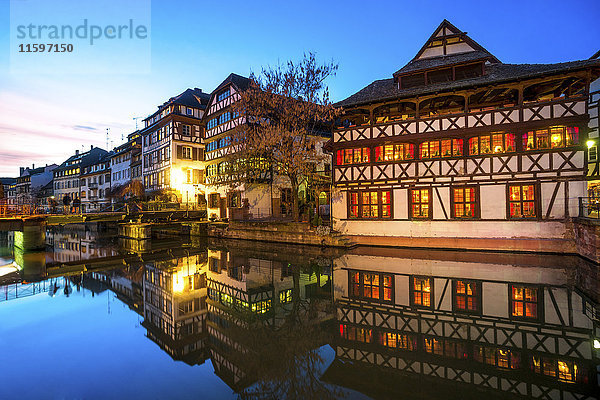 Frankreich  Straßburg  La Petite France  mit Fachwerkhäusern und dem Fluss L'Ill im Vordergrund zur blauen Stunde.