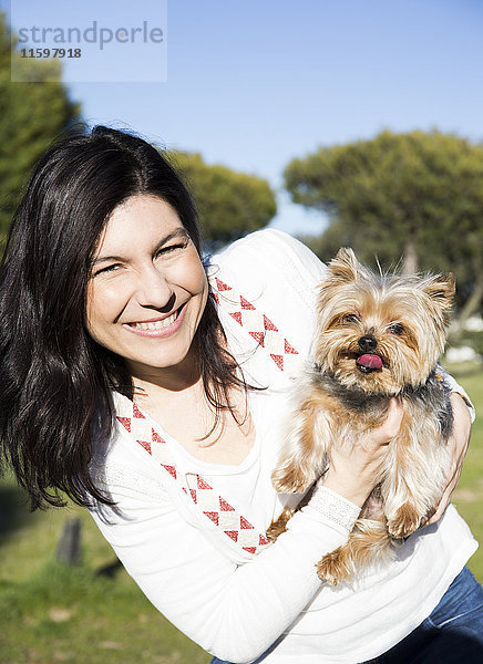 Porträt einer glücklichen jungen Frau mit ihrem Yorkshire Terrier