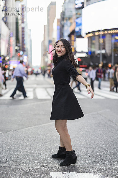 USA  New York City  Manhattan  fröhliche junge Frau im schwarzen Tanz auf der Straße