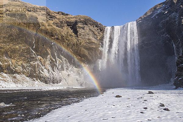 Island  Skogafoss Wasserfall mit Regenbogen im Winter