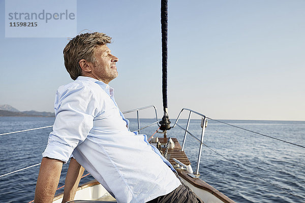 Der reife Mann entspannt sich auf seinem Segelboot