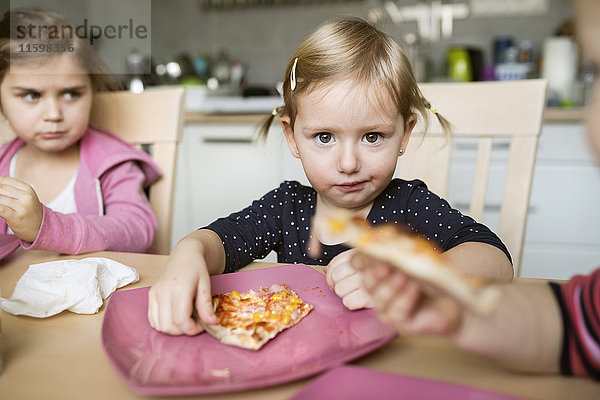 Kleine Mädchen zu Hause beim Pizzaessen