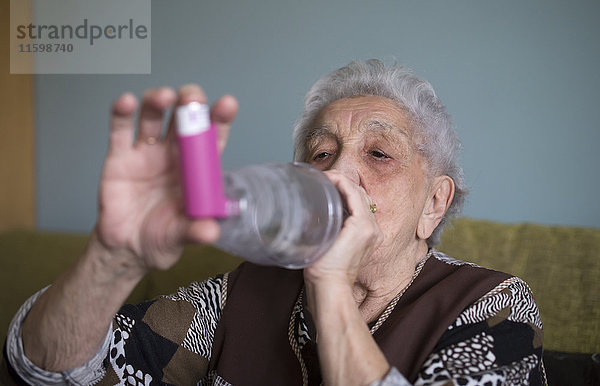 Seniorin mit Inhalator zu Hause