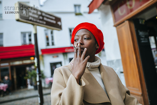 Junge Frau in Paris raucht eine Zigarette.