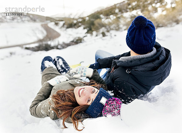 Junges Paar im Schnee liegend