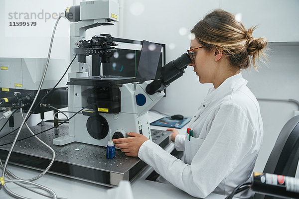 Labortechniker mit Mikroskop im Labor