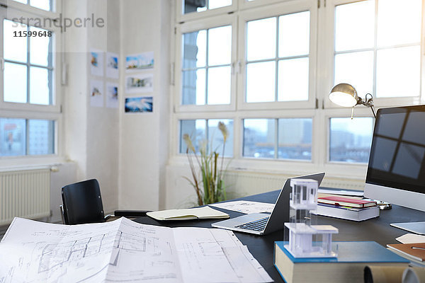 Schreibtisch mit Bauplan in einem modernen informellen Büro