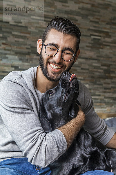 Porträt des Mannes mit seinem Hund zu Hause