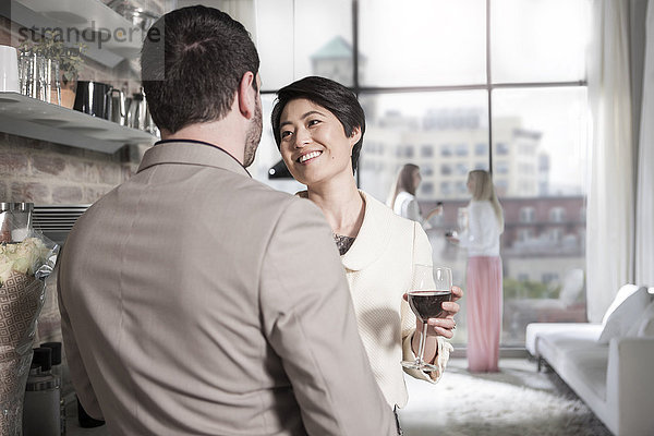 Mann und Frau mit Rotweinglas gesellig in einer Stadtwohnung