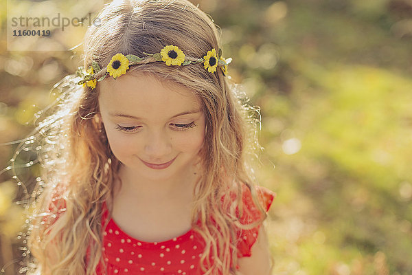 Porträt eines lächelnden kleinen Mädchens mit Blumenkranz