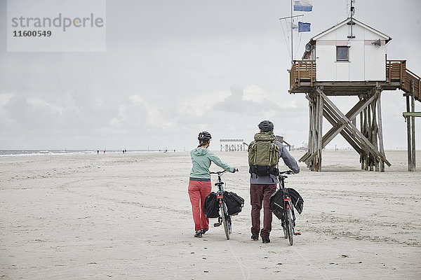 Deutschland  Schleswig-Holstein  St. Peter-Ording  Paar beim Fahrradfahren am Strand