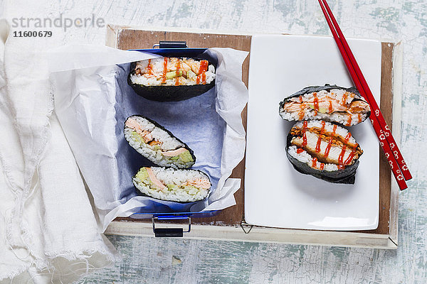 Sushi-Sandwiches mit Essstäbchen im Karton