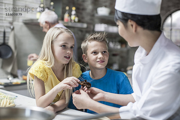 Junge und Mädchen stellen Fragen im Kochkurs