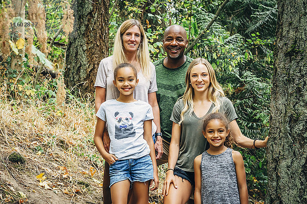 Multiethnische Familie posiert im Wald